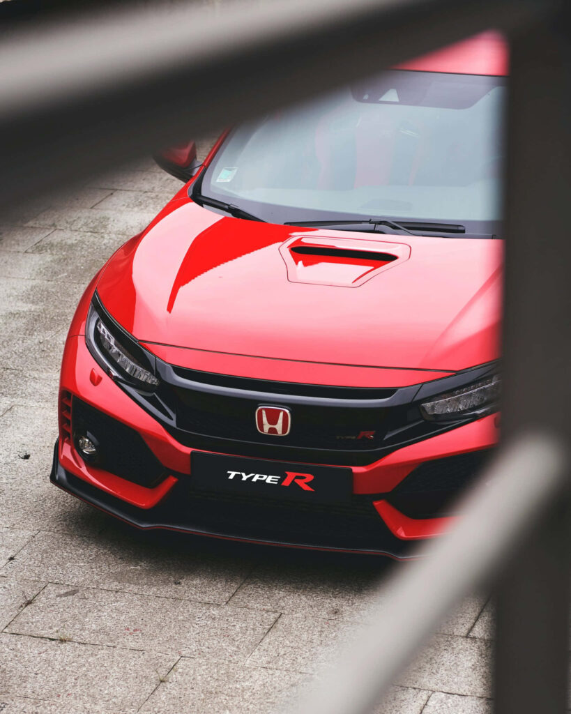 Red Honda Civic Type R parked on stone surface showing aggressive front design and badge Wallpaper