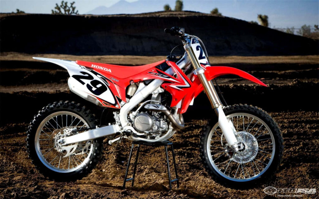 Red Honda Dirt Bike Wallpaper: Power & Design in Rugged Outdoors