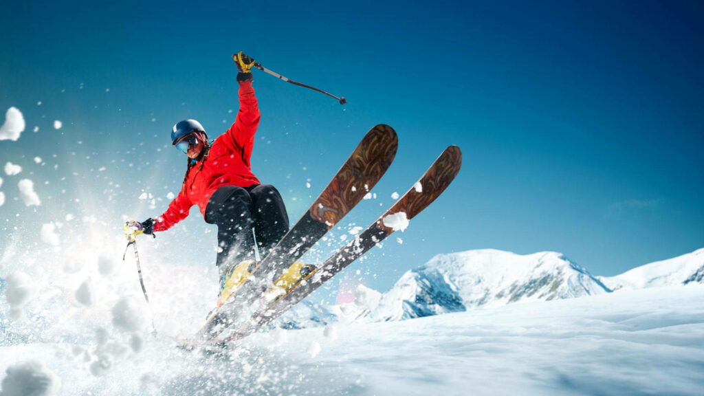 The Bold Leap: Capturing the Thrill of Ski Jumping in a Vibrant Red Jacket Wallpaper