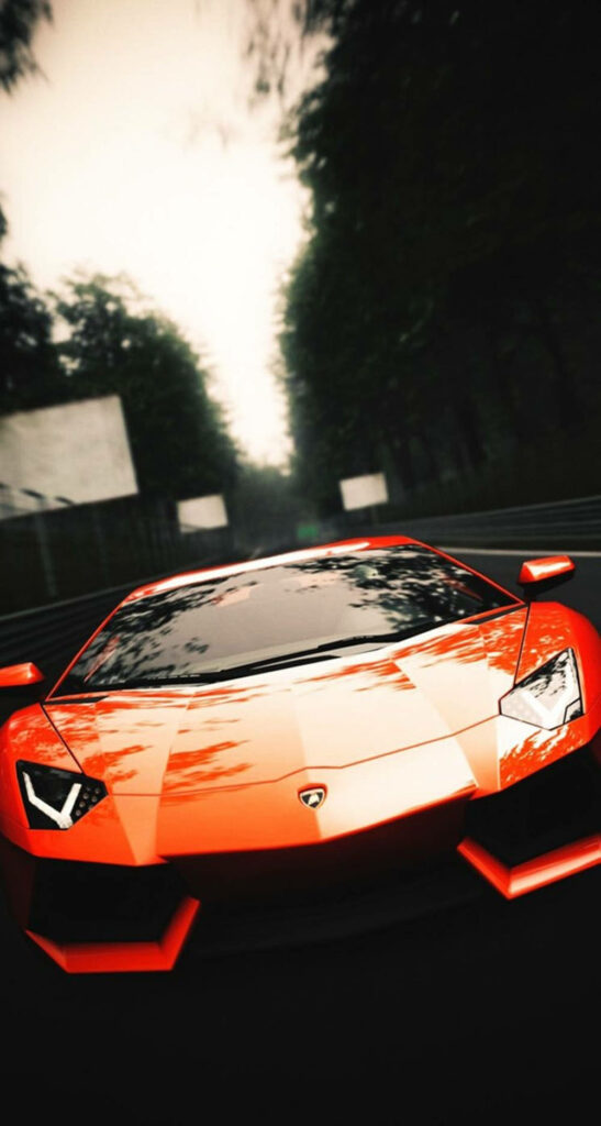 Red Lamborghini speeding on tree-lined road dynamic front angle sports car wallpaper background