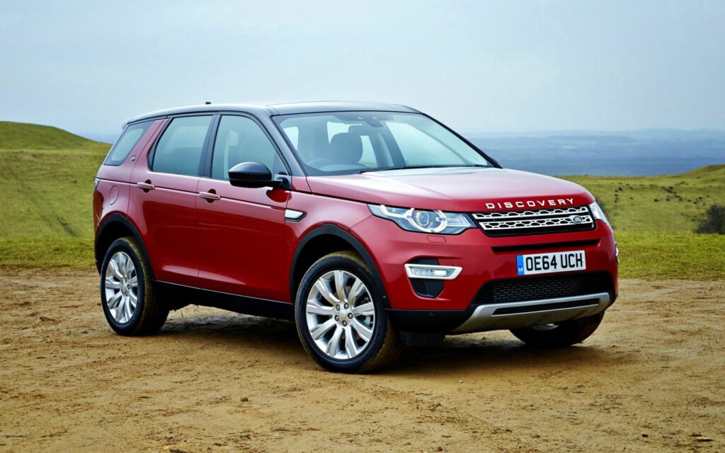 Red Land Rover Discovery Sport: Sleek Design in Scenic Outdoor Setting Wallpaper