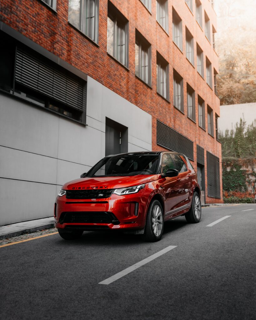 Red Land Rover Discovery in Urban Setting: Striking Wallpaper