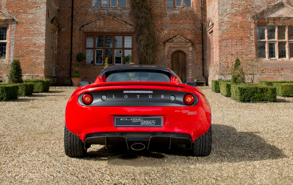 Stunning Lotus Sports Car Graces The Elegant Courtyard Of A Historic Manor Wallpaper