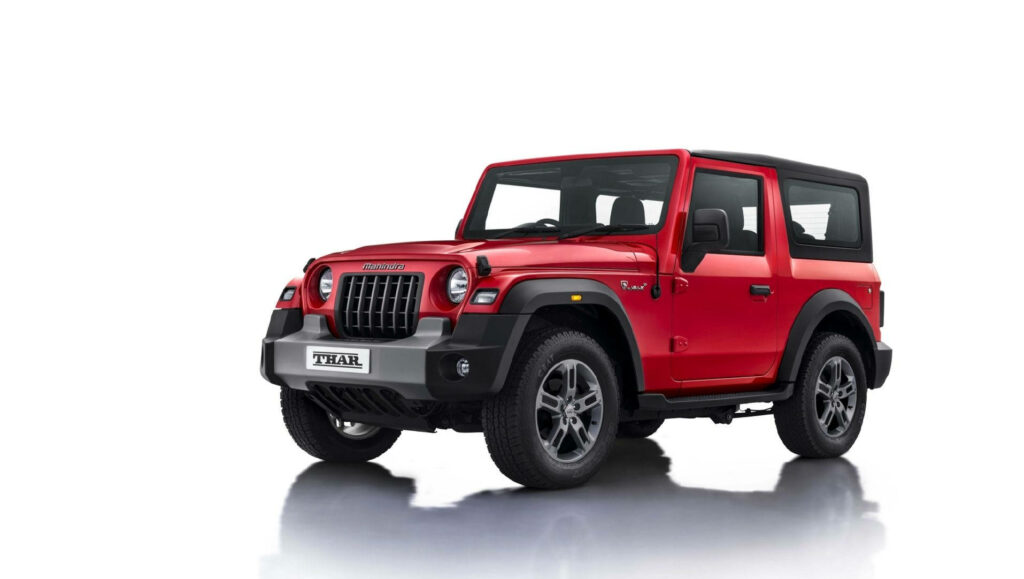 Red Mahindra Thar 2021 rugged SUV modern design bold style on clean white background wallpaper