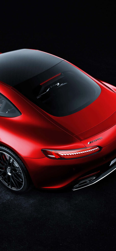 Red Mercedes AMG with sleek curves and luxurious design shining against dark background wallpaper