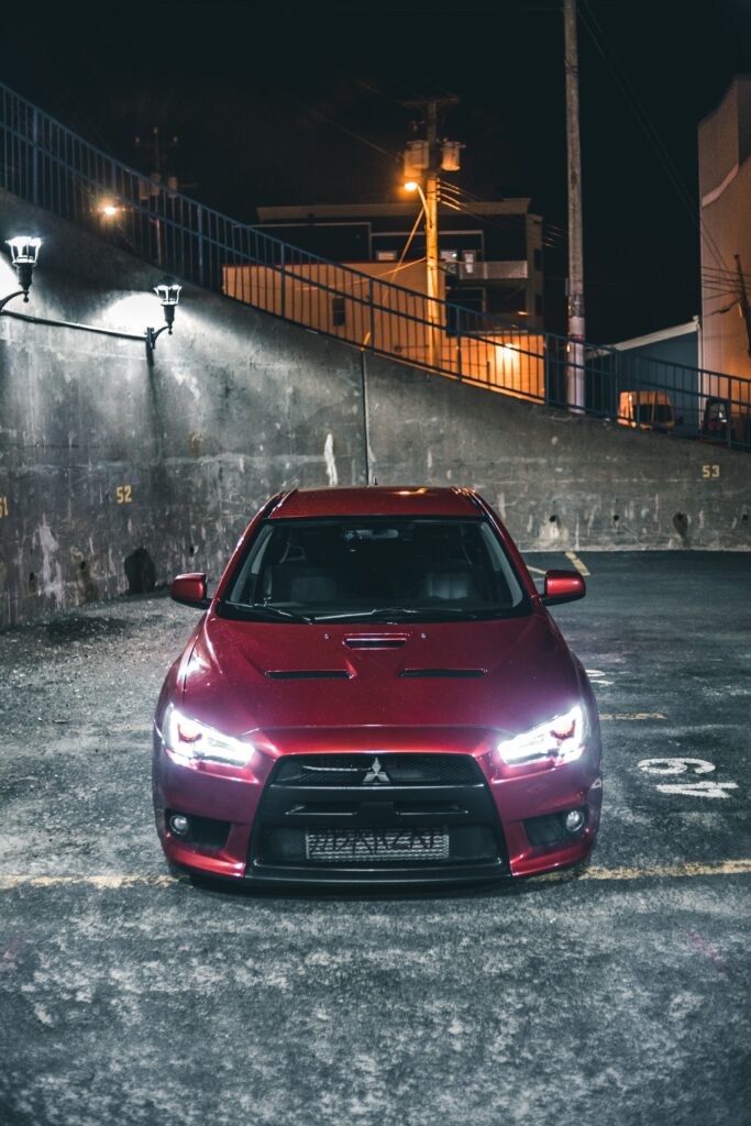 Stunning Night View of Red Mitsubishi Car in Urban Setting Wallpaper