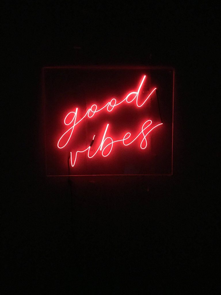 Red neon good vibes sign on black background minimalist moody aesthetic wallpaper background