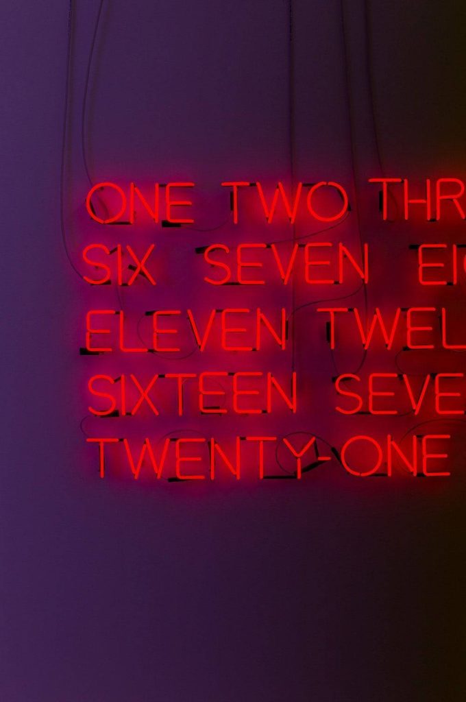 Red neon numbers one to twenty one glowing on black background modern typography wallpaper