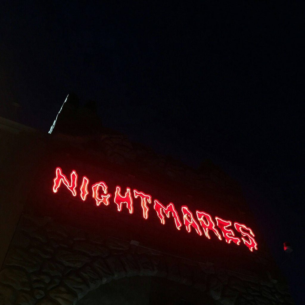 Red glowing NIGHTMARES neon sign on dark textured background dark neon aesthetic wallpaper