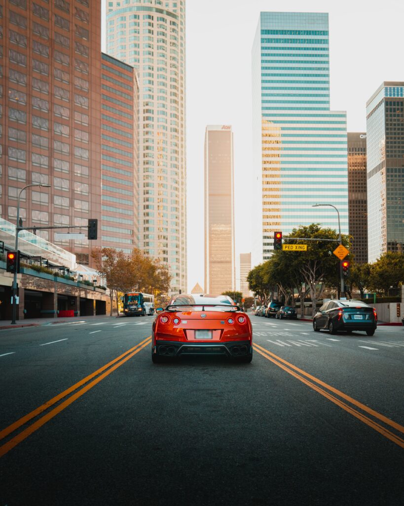 Red Nissan GT-R in Urban Skyline - Striking Cityscape Wallpaper