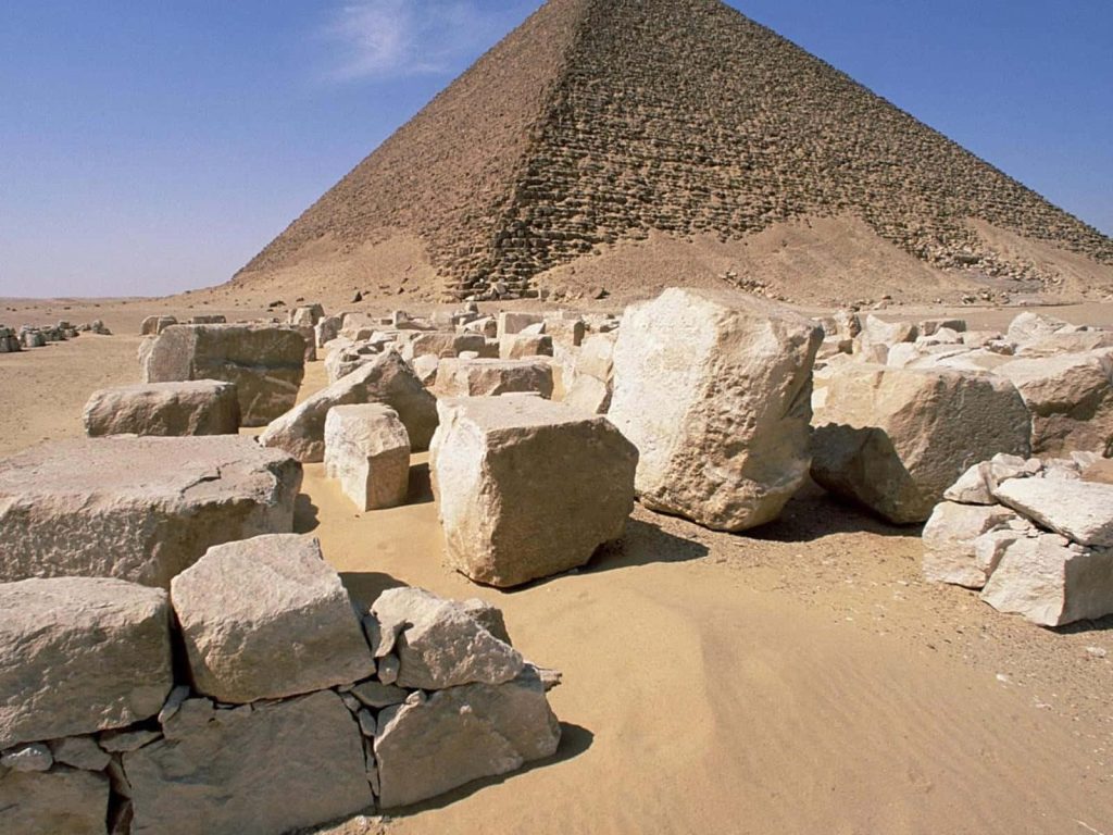 Red Pyramid at Dahshur with weathered limestone blocks on golden desert sand under bright sunlight Wallpaper