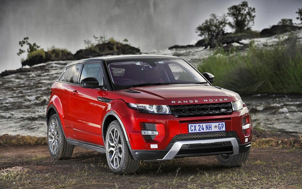 Red Range Rover Evoque by Waterfall in Scenic South Africa Wallpaper