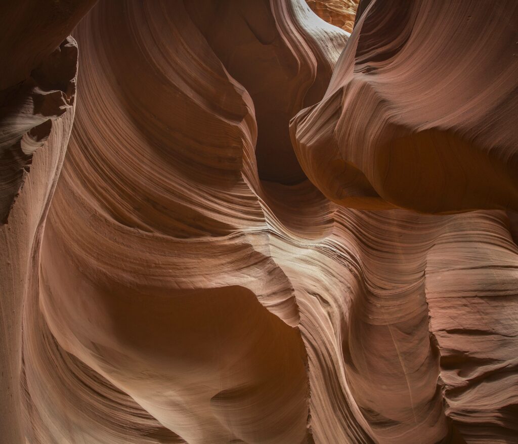 Red cave canyon wallpaper with smooth layered rock formations in vibrant orange and red hues
