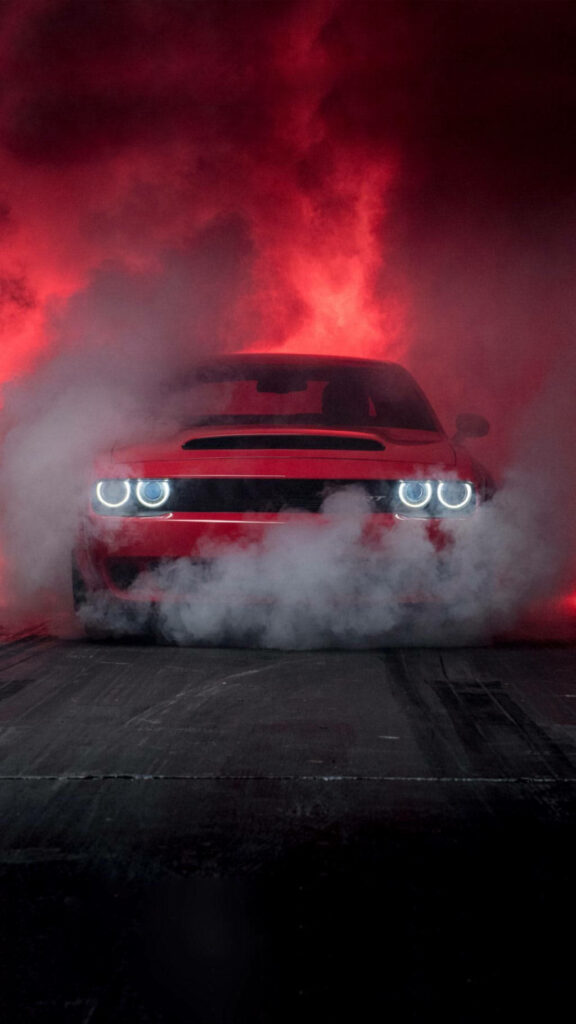 Red sports car speeds through thick smoke with dramatic red and black background wallpaper