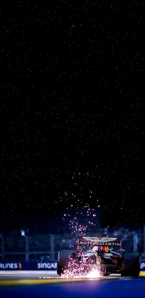 Redbull Formula One car racing at night in Singapore sparks flying vibrant OLED wallpaper background