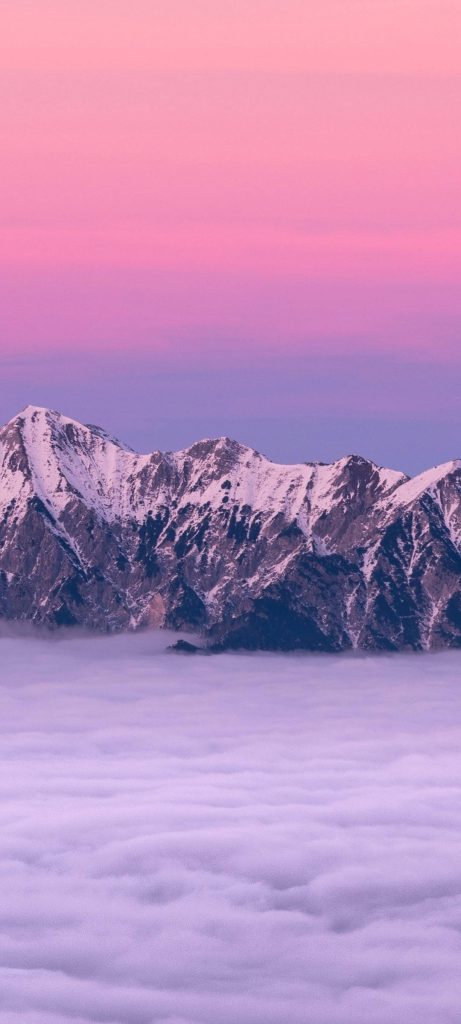Redmi Note 10 wallpaper snowy mountain peaks above clouds at pink lavender sunset background