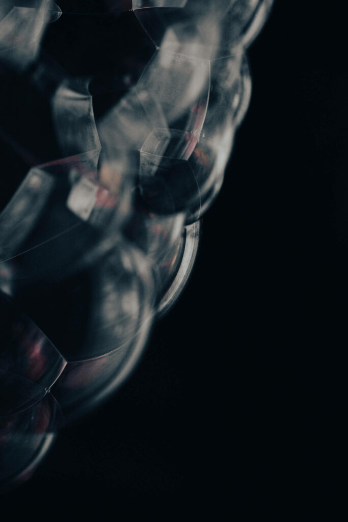 Captivating Macro Shot: Glowing Cluster of Glass Spheres Shines Against Obsidian Backdrop on iPhone X Dynamic Background Wallpaper
