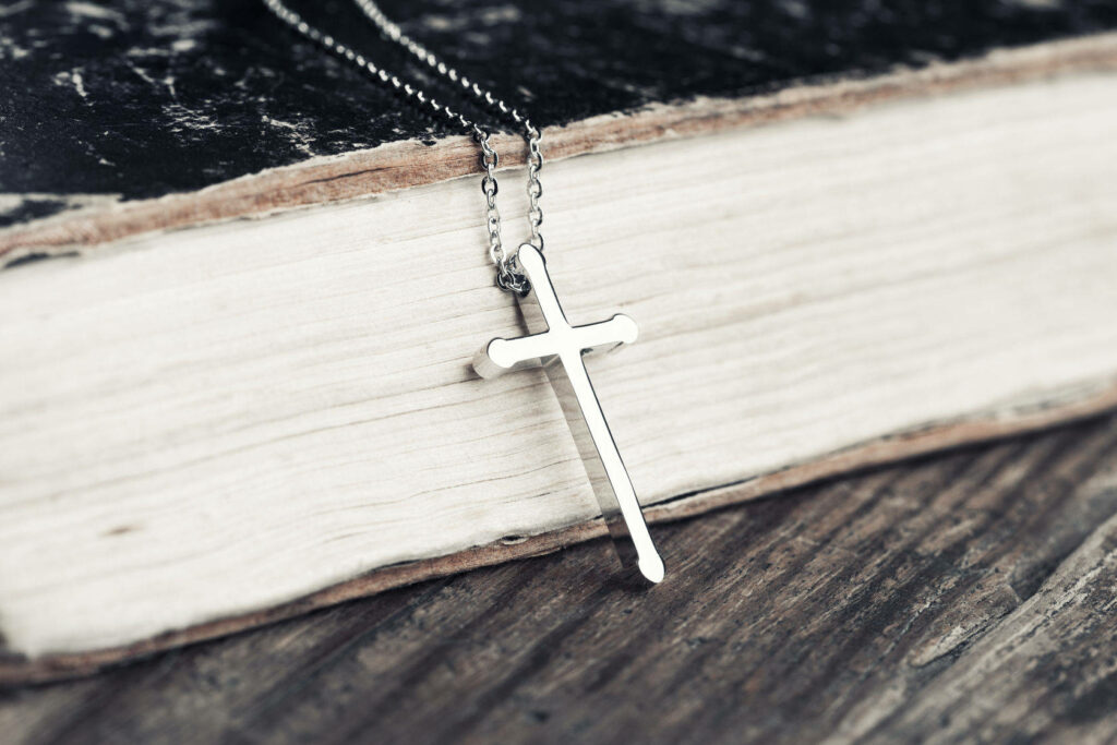 Divine Reflections: A Silver Christian Cross Wallpaper on Wooden Board Background