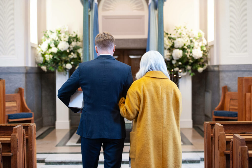 Reflections of Mourning: A Chapel Farewell with a Gentleman in Black and a Companionship of Mourner Wallpaper