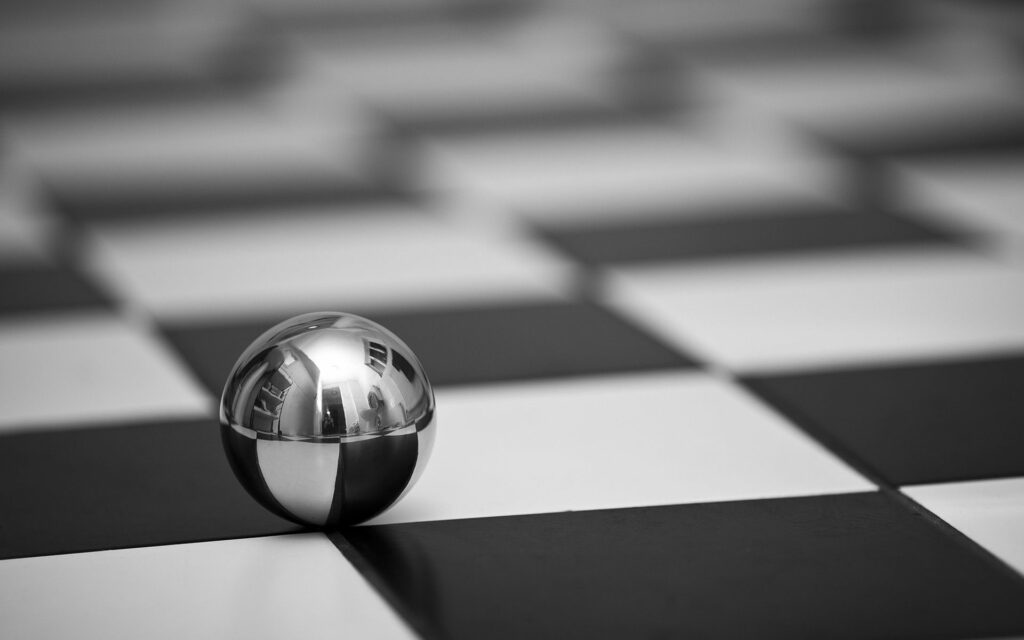 Reflective Metal Ball on Black & White Checkered Background - High Res Wallpaper
