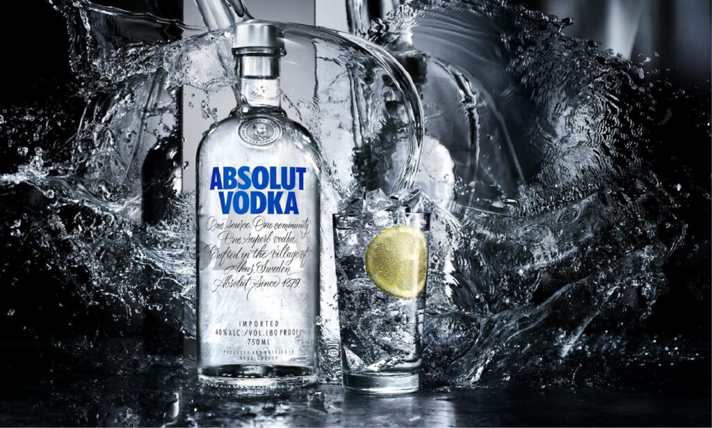Greyscale Absolut Vodka bottle with water splashes glass of vodka ice lemon slice wallpaper background