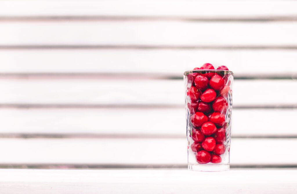 Vibrant Red Berries in Glass - Fresh Minimalistic Wallpaper Background