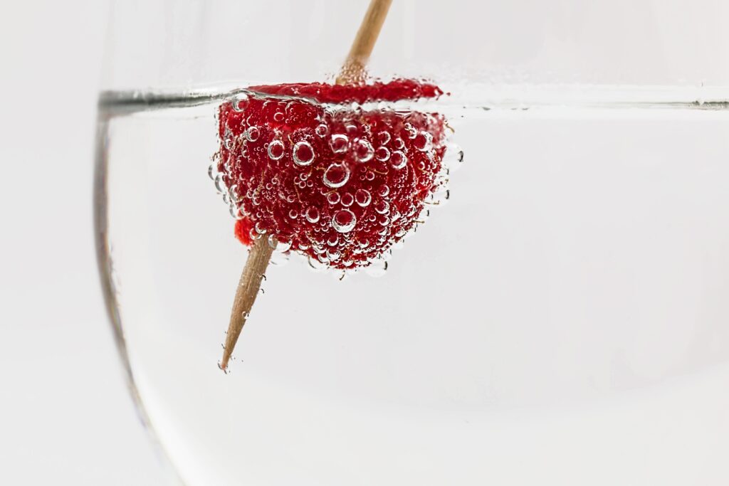Refreshing Raspberry Close-Up in Clear Liquid - Minimalistic Wallpaper