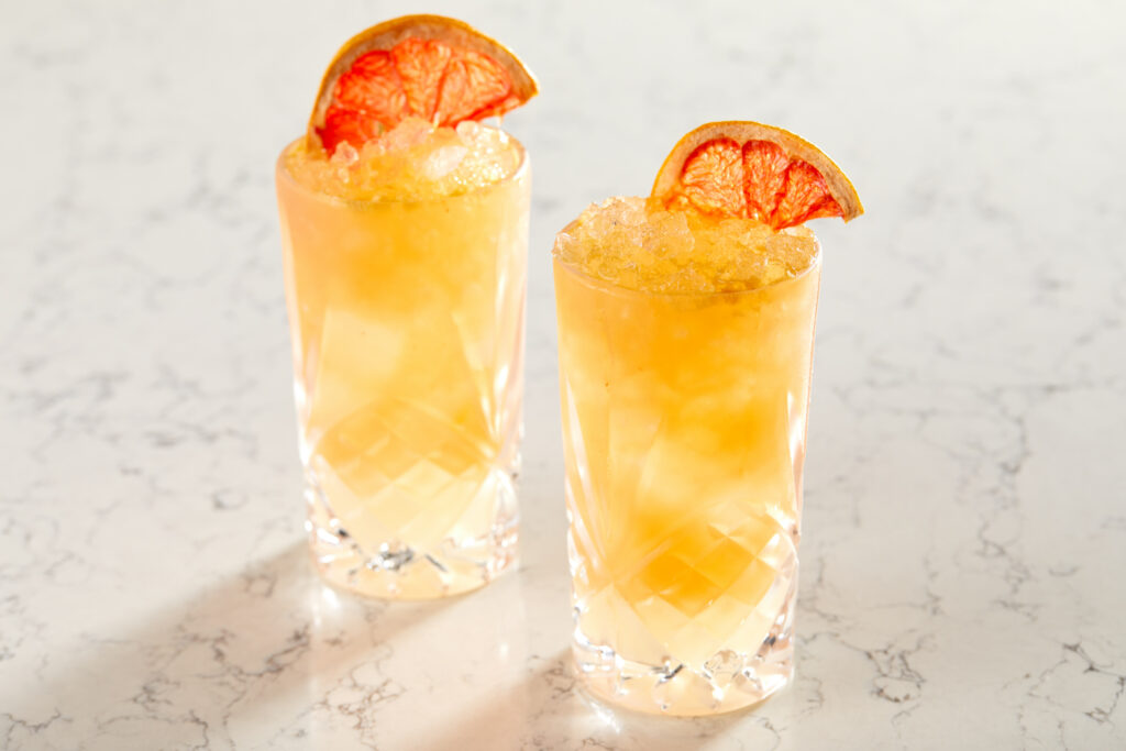 Vibrant Cocktail Wallpaper: Tall Glasses & Orange Garnish