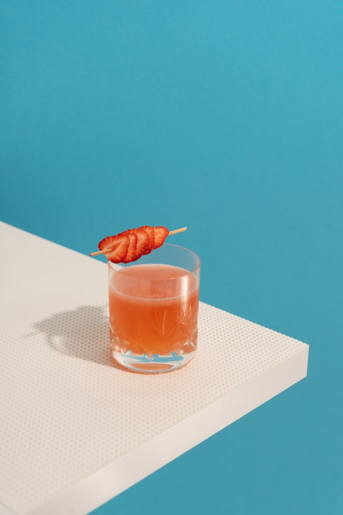 Refreshing Strawberry Cocktail in Clear Glass - Blue Wallpaper Background