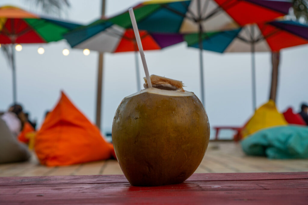 Refreshing Coconut Drink by the Beach - Vibrant Wallpaper Background