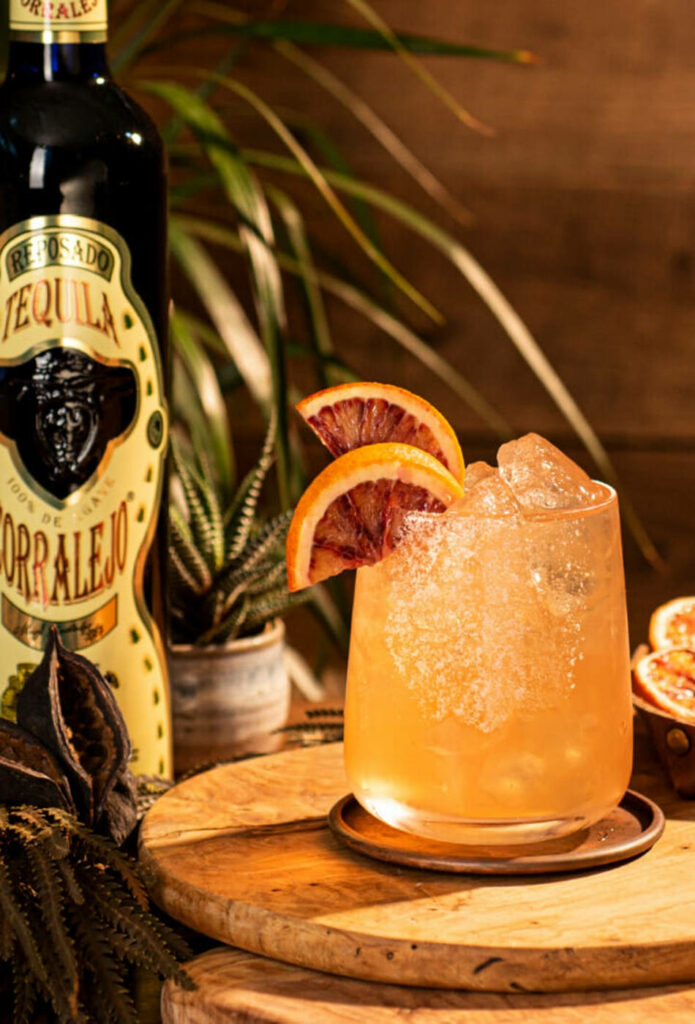 Refreshing Corralejo Tequila Reposado grapefruit cocktail with ice and fresh slices on rustic wood Wallpaper