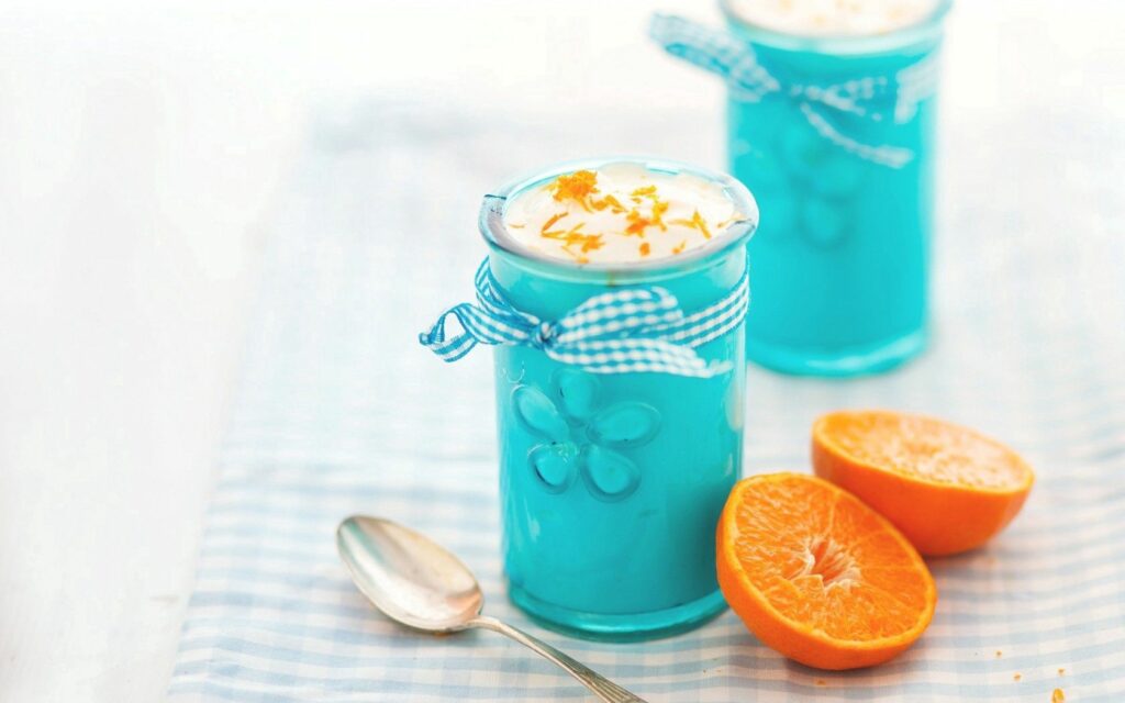 Refreshing Dessert Wallpaper: Blue Cups & Citrus on Checkered Surface