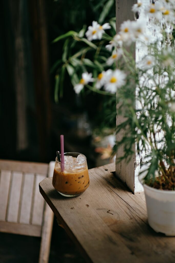 Charming Iced Coffee Wallpaper with Chamomile and Greenery Backdrop
