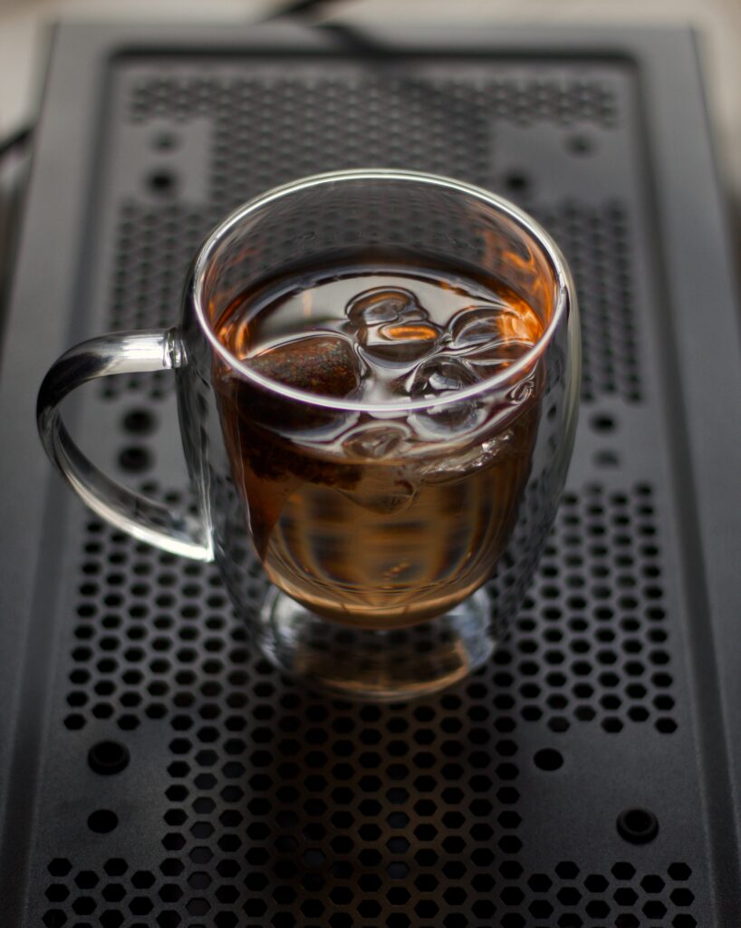 Iced Tea in Glass Cup: Refreshing Drink on Stylish Perforated Wallpaper