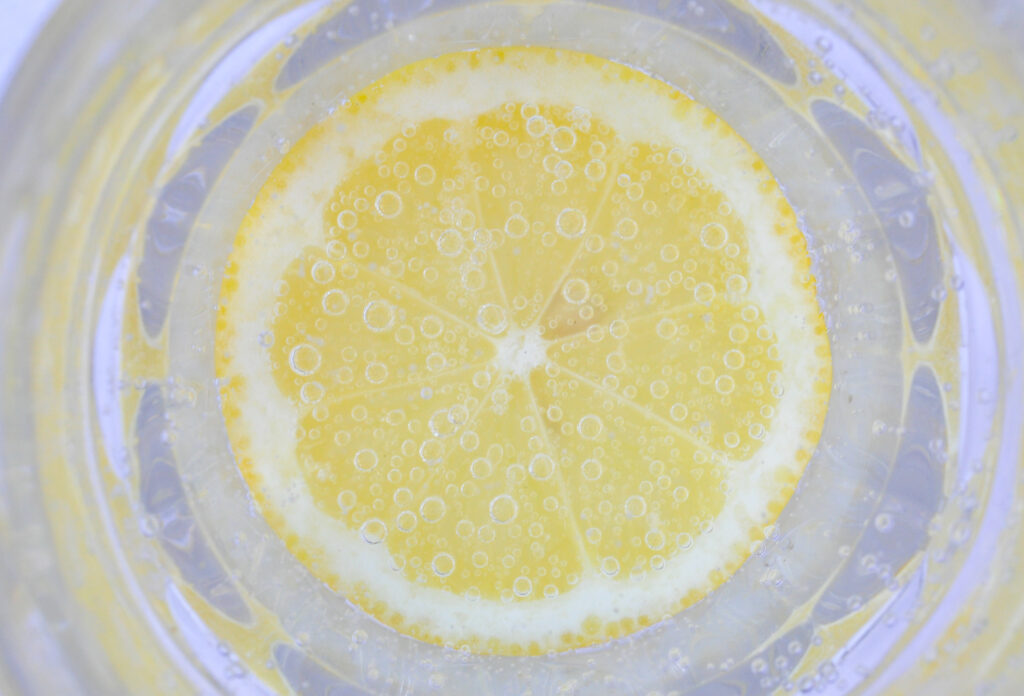 Vibrant Lemon Slice in Water - Refreshing Macro Wallpaper Background