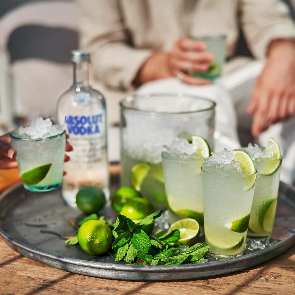 Refreshing lime cocktail with Absolut Vodka ice fresh lime slices and mint summer wallpaper background