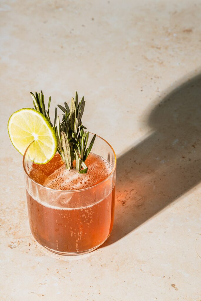 Vibrant Cocktail with Lime & Rosemary on Minimalist Wallpaper