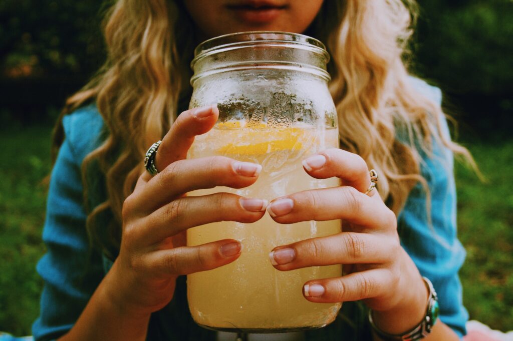 Refreshing Mason Jar Drink: Greenery Background & Ringed Hands Wallpaper