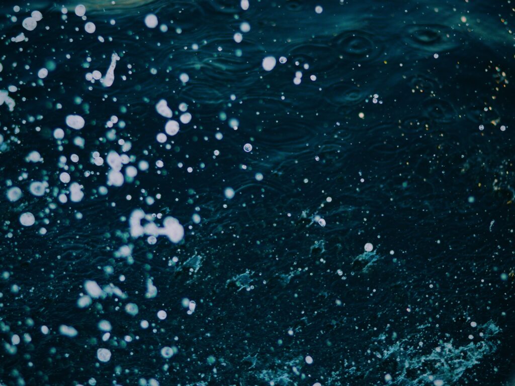 Dynamic ocean water splashes and sprays on deep blue sea background wallpaper background