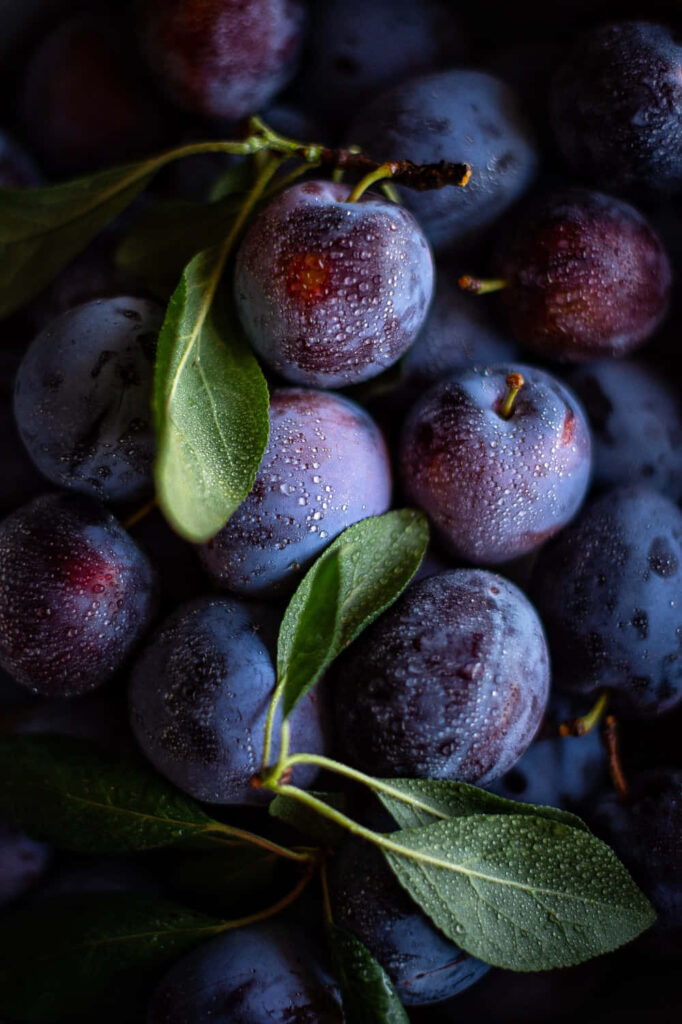 Refreshing Plum Wallpaper: Close-Up of Fresh Plums with Water Droplets