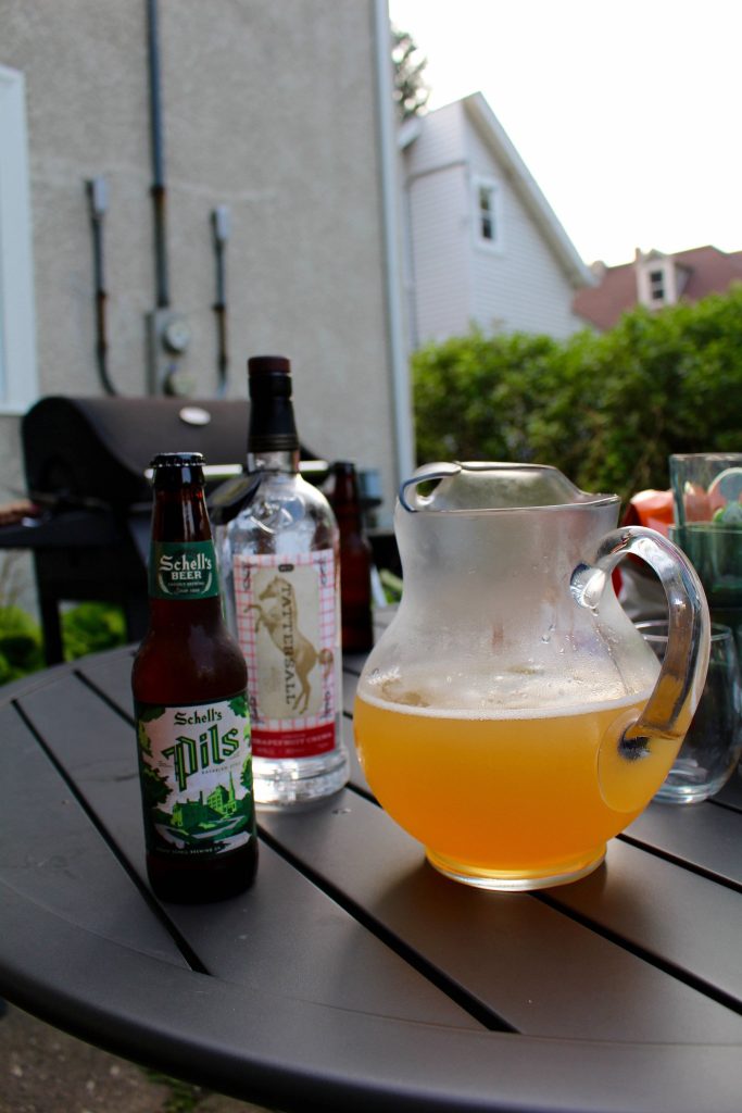 Schells Pils beer and Tattersall Grapefruit Crema with golden cocktail on sunny patio table Wallpaper