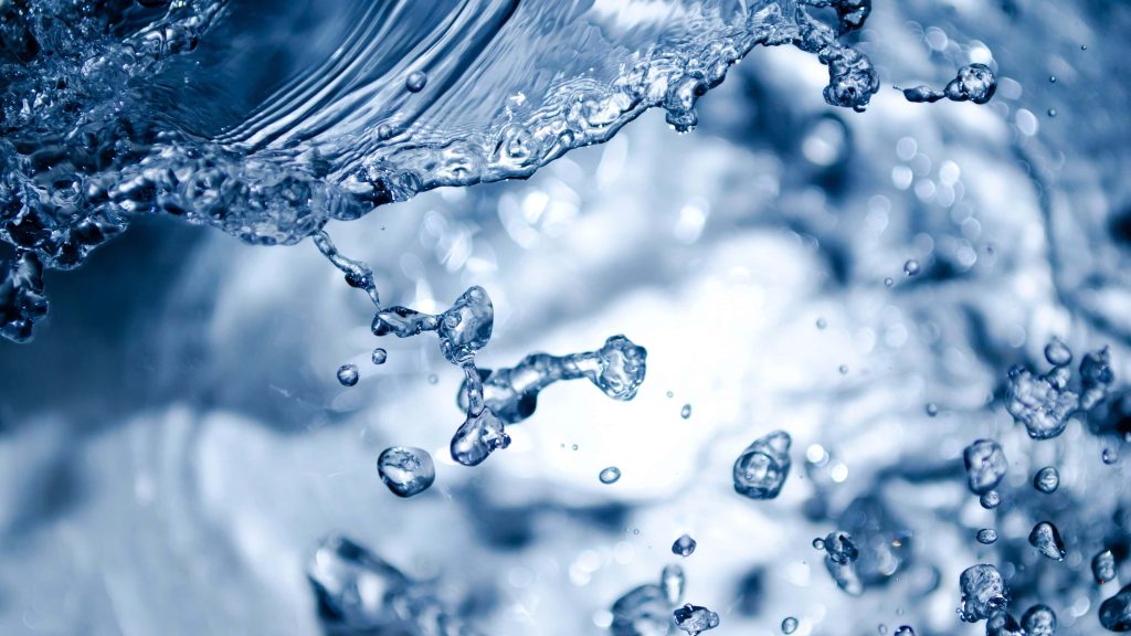 Vibrant macro shot of crystal-clear blue water droplets splashing in high-speed motion wallpaper