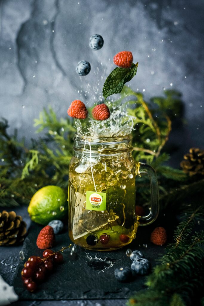 Vibrant Tea Splash with Berries - Refreshing Wallpaper Background
