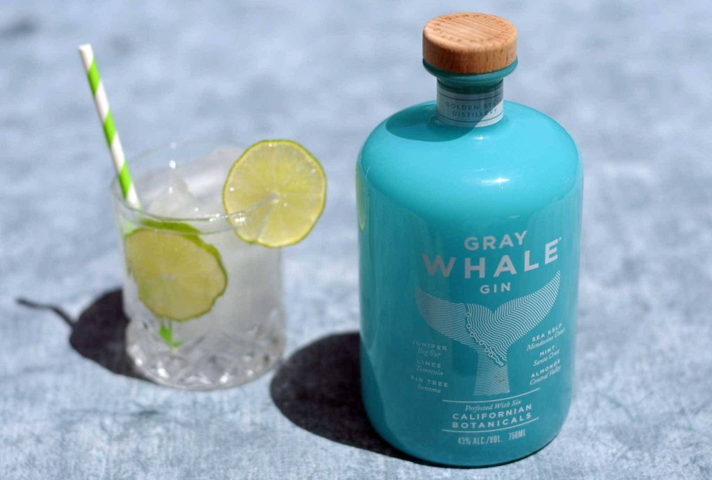 Teal Gray Whale Gin bottle with chilled cocktail lime garnish striped straw bright sunlight summer vibe Wallpaper