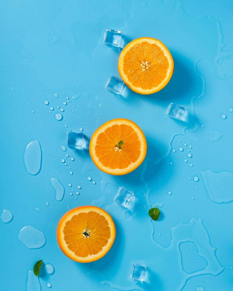 Vibrant Blue Background with Orange Slices and Ice - Refreshing Wallpaper