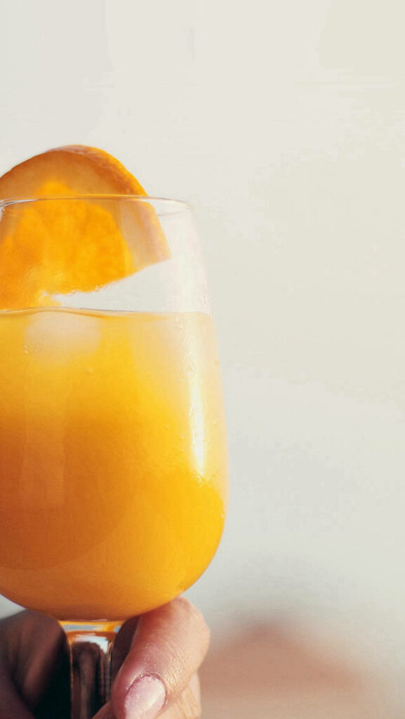 Vibrant iPhone Wallpaper: Chilled Orange Juice with Ice & Garnish