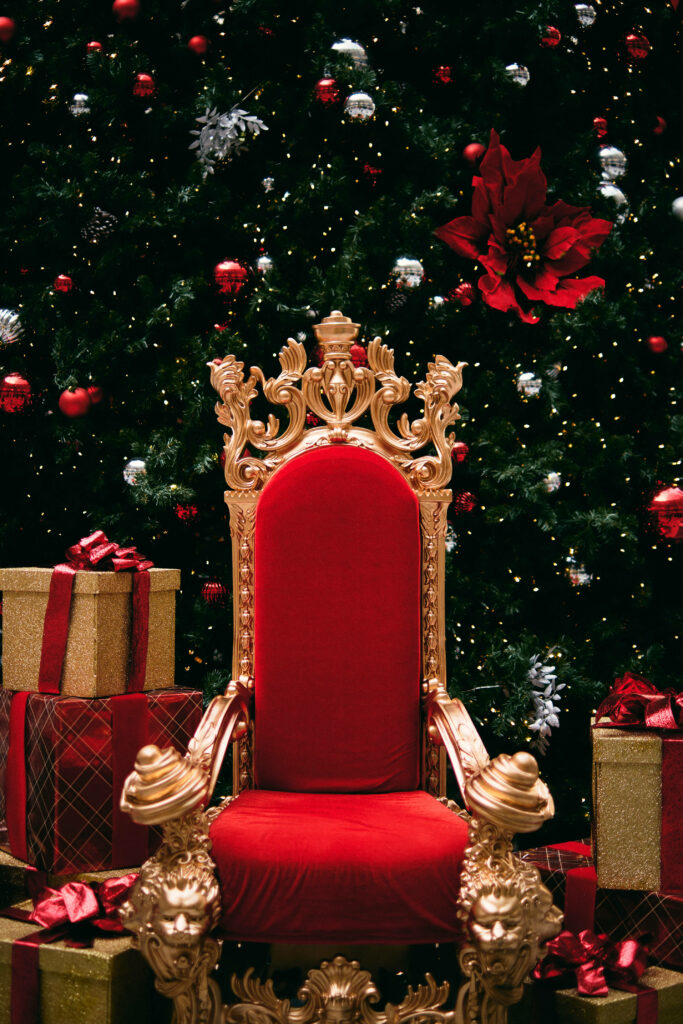 Regal Christmas Scene: Luxurious Red Throne & Festive Gifts Wallpaper