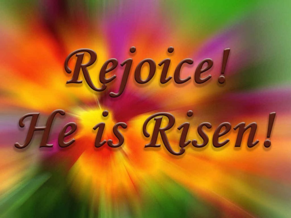 Easter wallpaper with Rejoice He is Risen embossed text on vibrant rainbow sunburst background