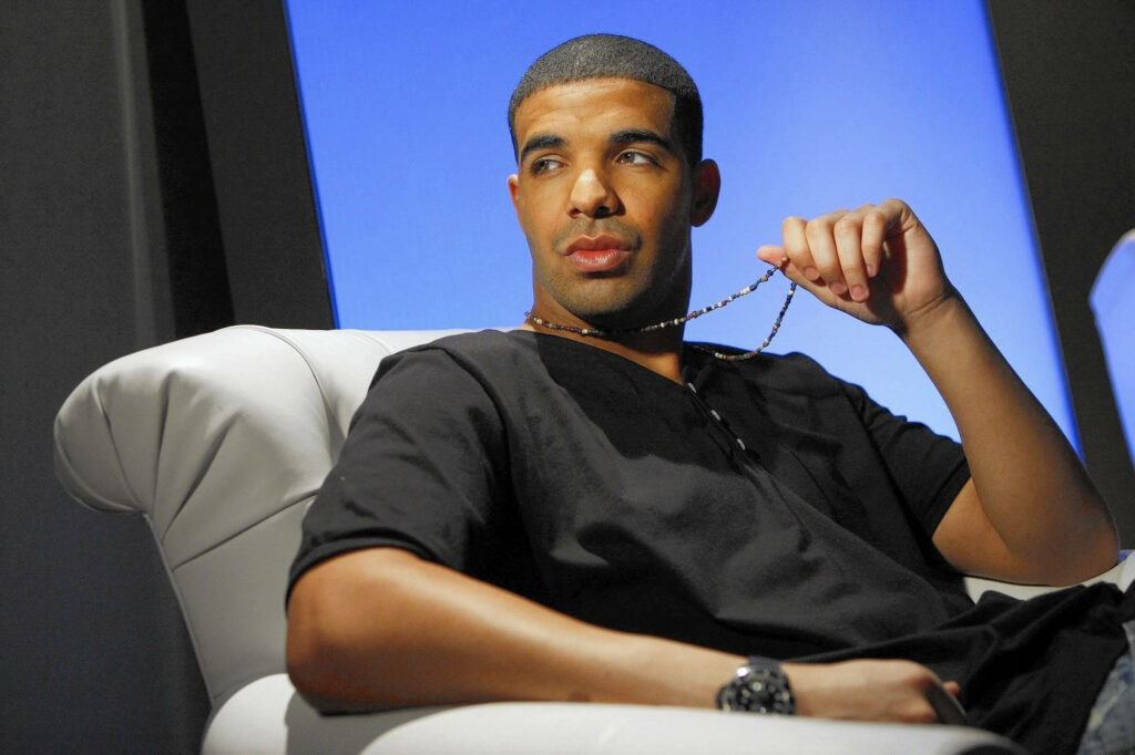 Thoughtful Drake Interview Wallpaper on Vibrant Blue Background