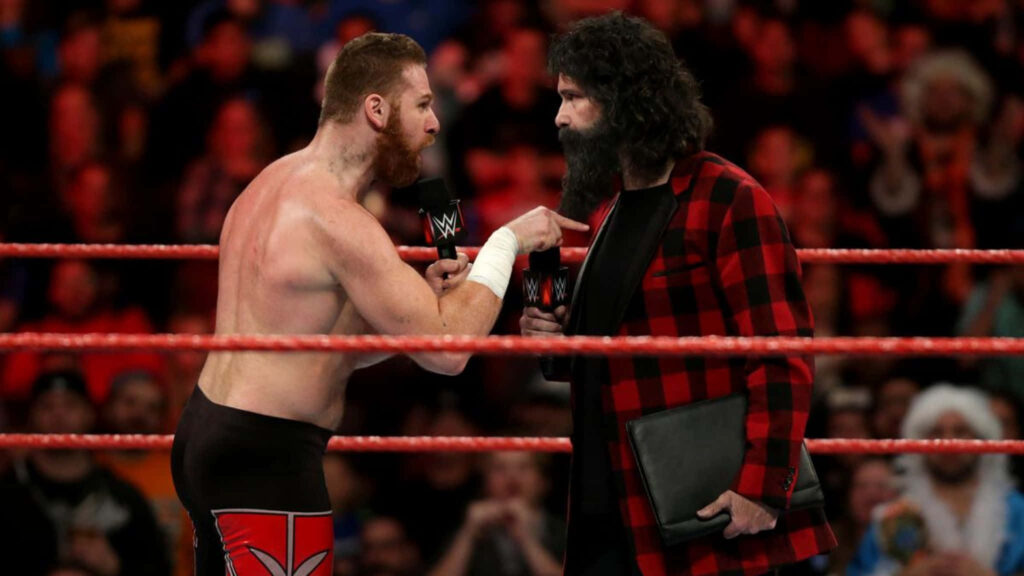 The Showdown: Mick Foley and Sami Zayn Face-off in WWE Ring Wallpaper